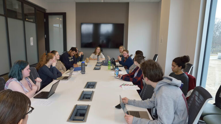 students collaborating around an office table